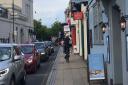 A cyclist riding on the pavement in Chequer Street, St Albans.