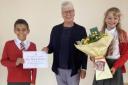 Mary Driver receives a certificate and flowers from pupils at William Ransom School to mark her retirement as headteacher.