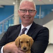 Hitchin Boys' School's head Fergal Moane with one of the eight week old puppies that visited the school this week