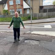 Liberal Democrat Councillor Stephen Giles-Medhurst points to hefty pothole