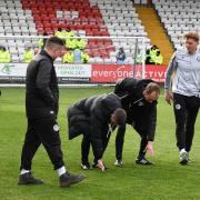 Match officials inspect the pitch before postponing Stevenage's home game with Barnsley. Picture: TGS PHOTO