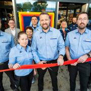 Manager Kyle Fitzgerald (centre) cut the ribbon to officially reopen the store.